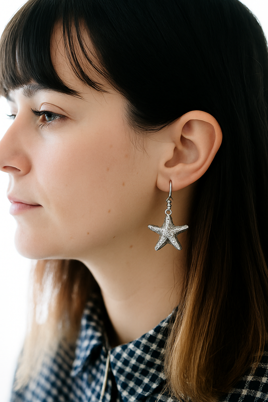Modelo con aretes de plata en forma de estrella de mar 