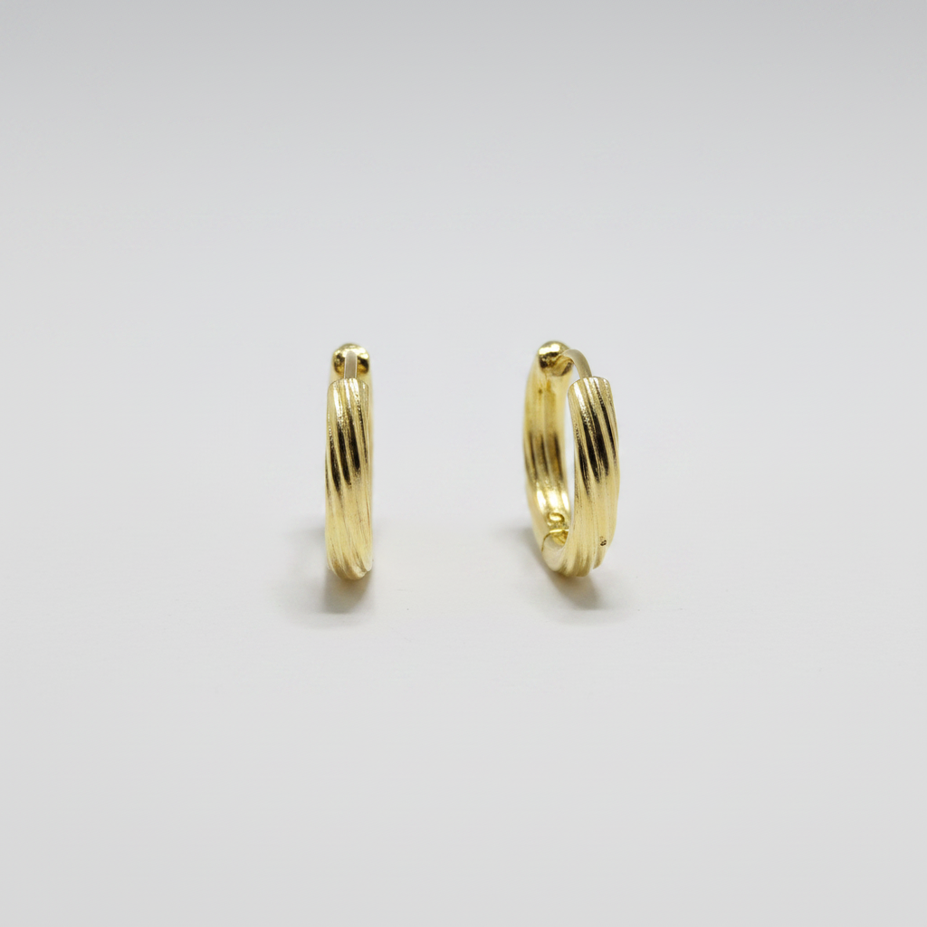 Aretes argolla huggies medianas en plata .925 con chapa de oro amarillo y acabado acanalado diagonal