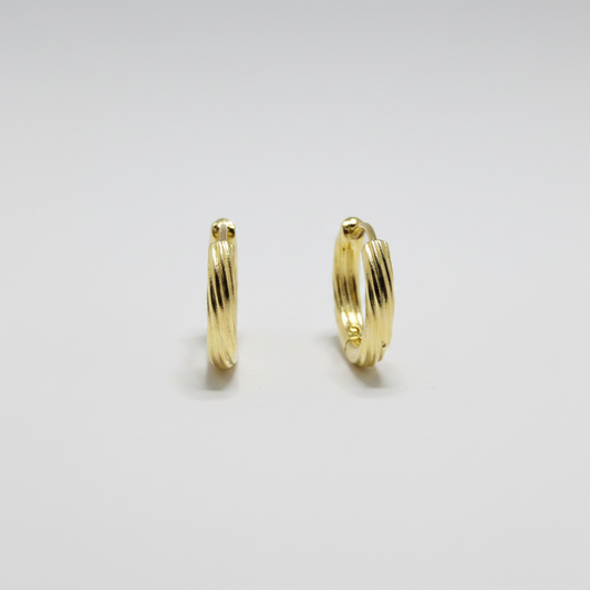 Aretes argolla huggies medianas en plata .925 con chapa de oro amarillo y acabado acanalado diagonal