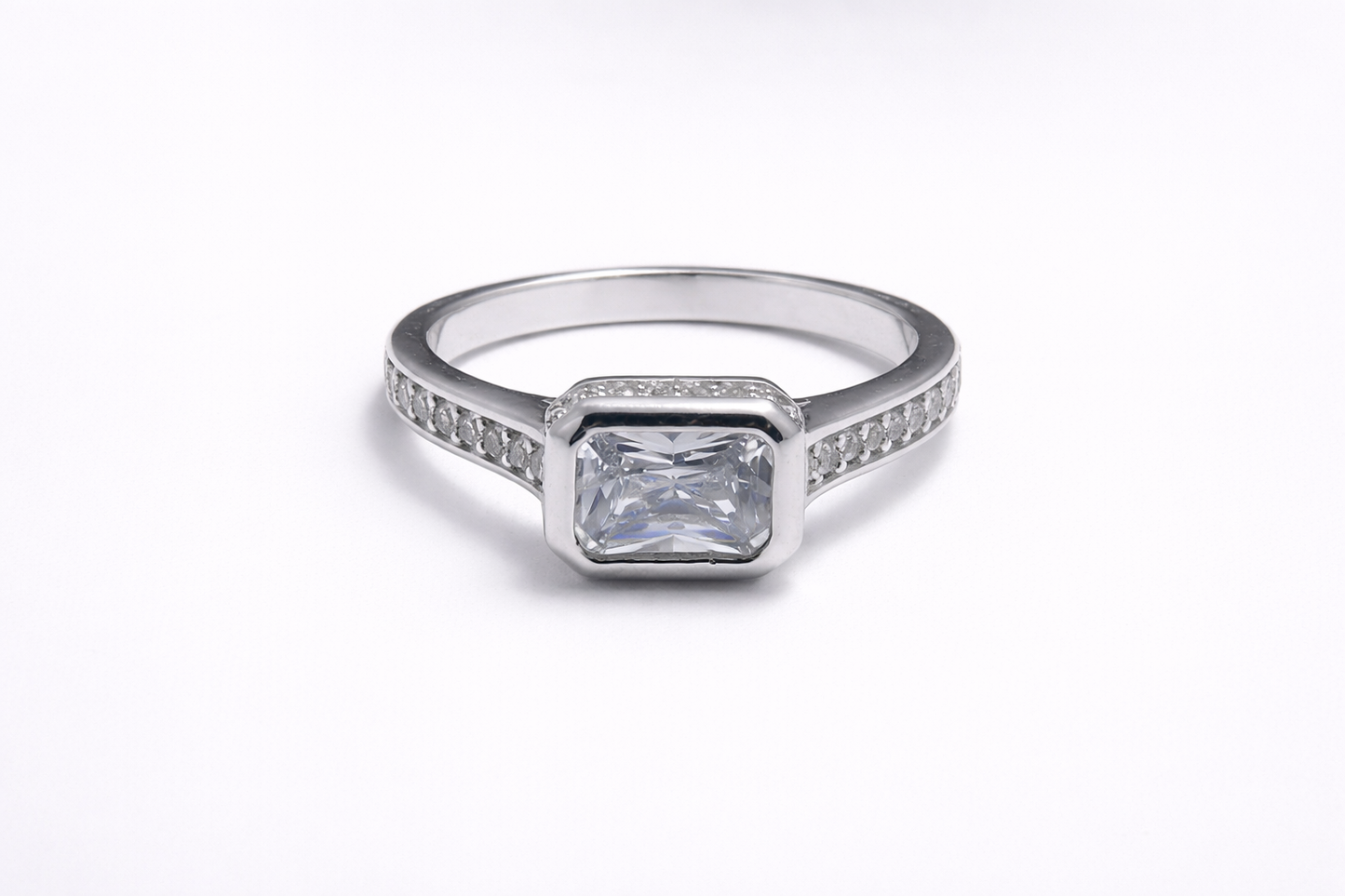 Anillo de Plata .925 - Solitario con Hombros de Pavé Canal y Zircón Blanco Esmeralda en Engaste Bisel Marco